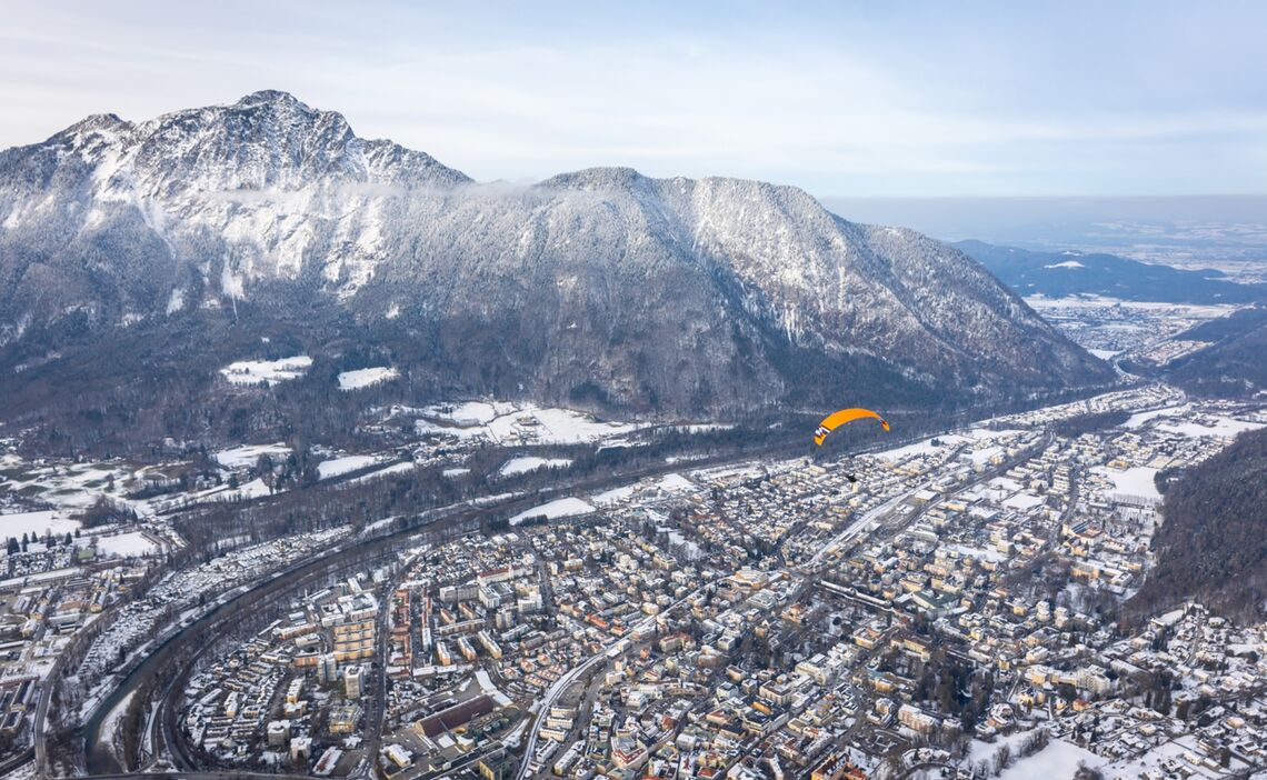 Paragleiter über der winterlichen Alpenstadt